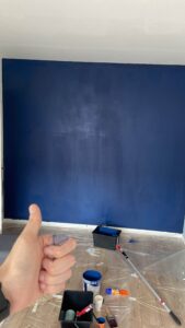 a hand and a painted wall